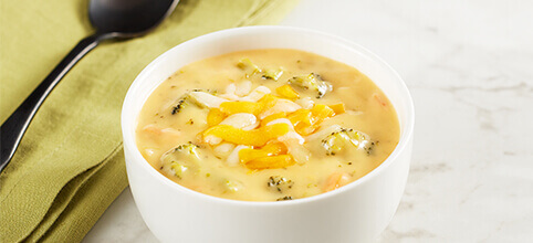 A bowl of broccoli cheddar soup with creamy cheese and tender broccoli pieces.