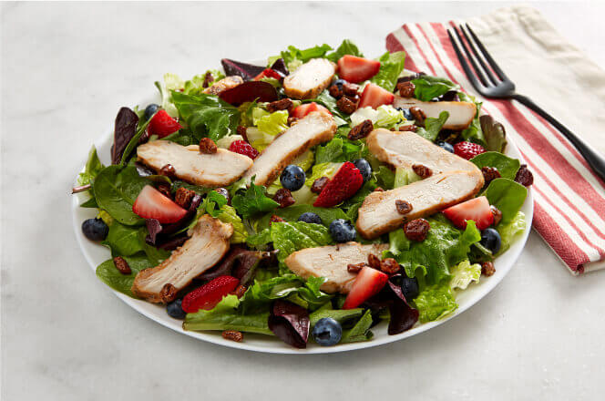 A Pecanberry salad with mixed greens, grilled chicken, pecans, and cranberries.