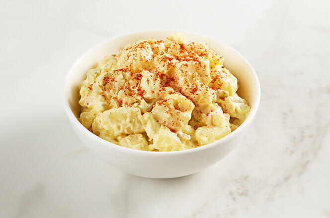 A serving of potato salad with creamy dressing.