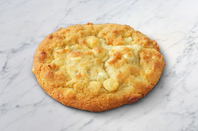 A white chocolate macadamia nut cookie with chunks of macadamia nuts.