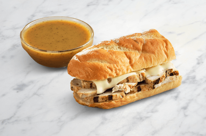A mini chicken dip sandwich with shredded chicken on marble rye bread and au jus sauce.