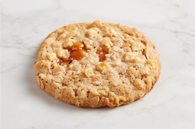 A soft apple caramel cookie with caramel drizzle and apple chunks.