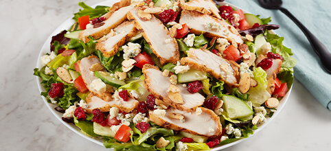 An assortment of fresh salads displayed with vibrant greens and colorful toppings.